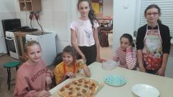 Uczniowie przygotowujący pizzę w ramach zajęć koła Akademia Młodego Kucharza